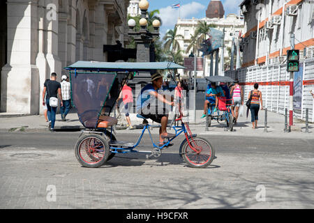 Un homme cubain conduit son taxi à vélo en pousse-pousse à trois roues dans les rues animées de la Havane Vieja Cuba Banque D'Images