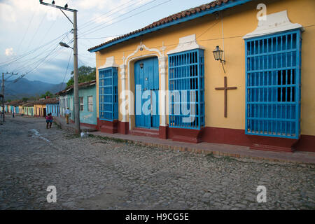 À la recherche dans une rue de Trinidad Cuba avec colouful peint pastel maisons et des habitants assis Banque D'Images