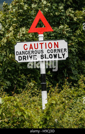 Old fashioned road sign, attention coin dangereux conduire lentement Banque D'Images