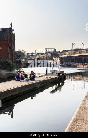 Un petit groupe d'amis qui se socialisent à Camden Lock sur Regent's Canal, Camden Town, Londres, Royaume-Uni