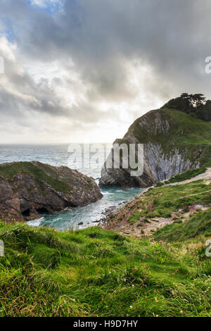 Les nuages de tempête de Lulworth Cove, rassemblant plus de Dorset, Angleterre, RU, un soir d'été Banque D'Images