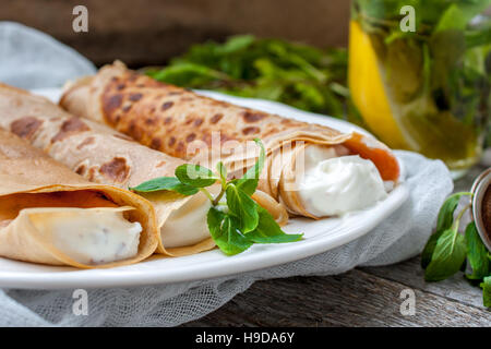 Crêpes minces russe avec beurre, fromage, confiture, menthe sur une serviette sur un fond de bois. L'amour pour la santé de sweet food concept Banque D'Images