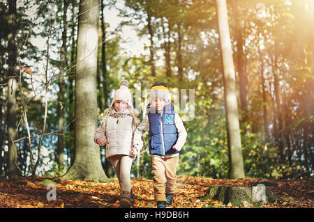 Une paire d'enfants heureux dans la forêt d'automne. Tourné en extérieur horizontal Banque D'Images