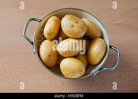 Légumes crus non cuits légumes pommes de terre nouvelles dans un bol à passoire récipient pot par le dessus Banque D'Images