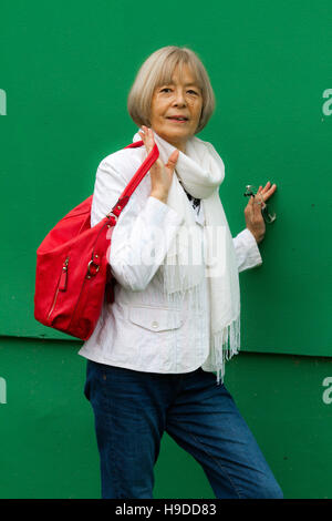 Les cadres supérieurs japonais pose dans un manteau blanc avec sac à bandoulière rouge Banque D'Images