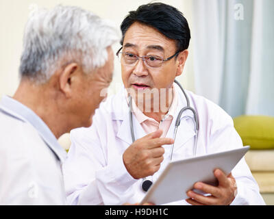 Médecin asiatique expliquant l'état de santé d'un senior patient Banque D'Images