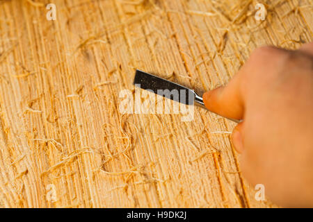 Les copeaux de bois et les couteaux se situent sur une planche en bois close-up. Banque D'Images