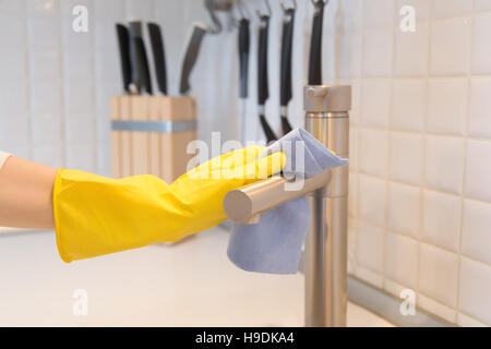 Image main de femme libre de gants de nettoyage du robinet de cuisine Banque D'Images