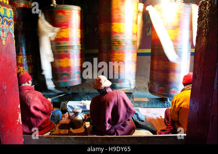 Moines au monastère de Tawang grand spin roues de prière tout en chantant des prières bouddhistes dans la vallée de Tawang à distance, de l'Inde. Banque D'Images