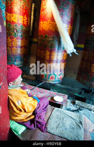 Moines au monastère de Tawang grand spin roues de prière tout en chantant des prières bouddhistes dans la vallée de Tawang à distance, de l'Inde. Banque D'Images