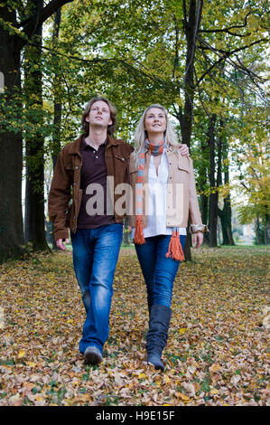 Jeune couple balade au cœur d'un parc d'automne Banque D'Images