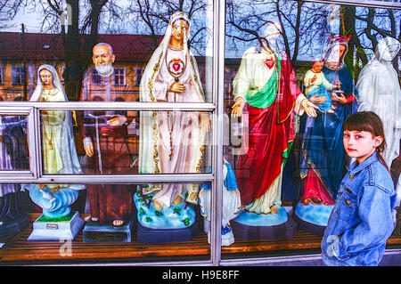 Czestochowa Pologne, jeune fille preteen devant la vitrine de la boutique avec des produits votifs religieux articles Saints catholiques romains sacrés Banque D'Images