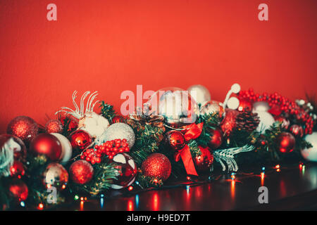 Guirlande de décoration de Noël avec des branches de sapin, rouge et argent baubles, pommes de pin et autres ornements, dans la nouvelle année historique Banque D'Images