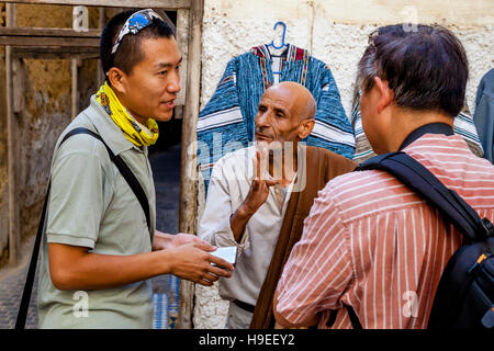 Les touristes chinois négociation collective dans la médina, Fès el Bali, FES, Maroc Banque D'Images