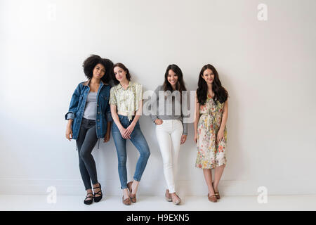 Portrait of smiling women leaning on wall Banque D'Images