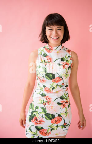 Smiling Hispanic woman wearing dress floral Banque D'Images