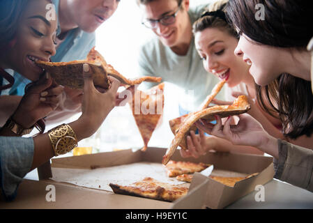 Les amis de manger les tranches de pizza Banque D'Images