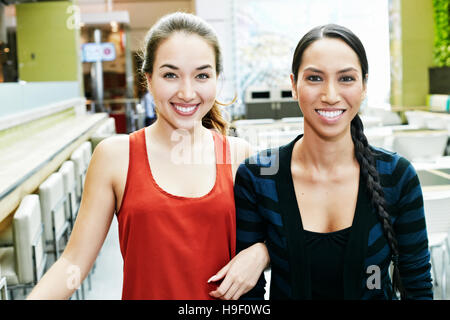 Asian women posing in food court Banque D'Images