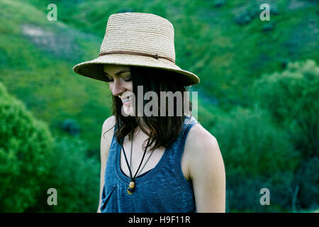 Smiling woman wearing hat sur hill Banque D'Images