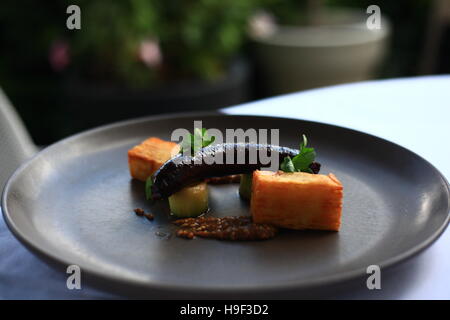 Boudin Noir saucisse avec mille feuille de pommes de terre, poireaux caramélisés et moutarde Banque D'Images