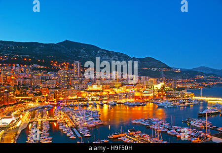 Panorama du Port Hercule avec les yachts et bateaux, entouré par des milliers de lumières de la ville, qui se reflète dans l'eau, de Monaco. Banque D'Images