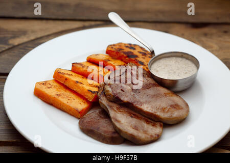 Langue de la viande avec la sauce et la citrouille Banque D'Images