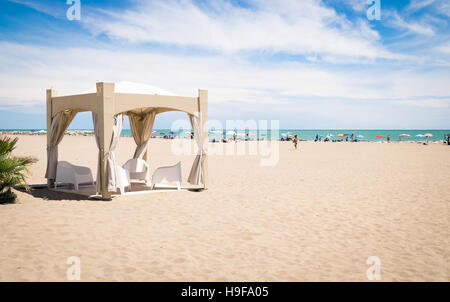 De couleur sable gazebo avec des chaises blanches sur la plage. Banque D'Images