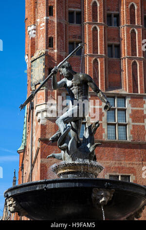 La sculpture de Neptune sur le dessus de la fontaine de Gdansk avec l'hôtel de ville en arrière-plan, Pologne Banque D'Images