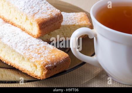 Des pâtisseries fraîchement préparées et une tasse de thé pour le petit-déjeuner close up Banque D'Images