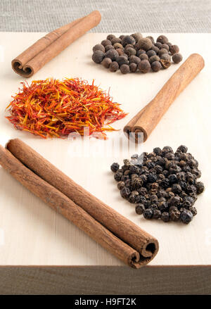 Condiments et épices - cannelle, piment, safran et de poivre sur un plateau en bois Banque D'Images