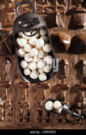 Kurt kurut - Boules de yogourt séché asiatiques sur fond en bois sculpté Banque D'Images