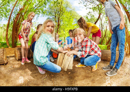 Heureux les enfants jouant avec des troncs dans la forêt Banque D'Images