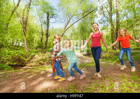 Enfants heureux de marcher dans le parc holding hands Banque D'Images