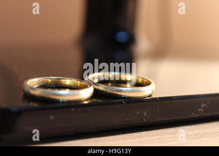 Anneaux d'or de mariage ensemble côte à côte sur un tableau noir Banque D'Images