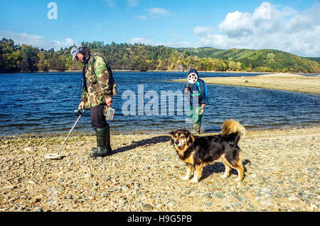 Les hommes avec détecteur de métal recherche des éléments sur la rive du barrage Orlik, République Tchèque Banque D'Images