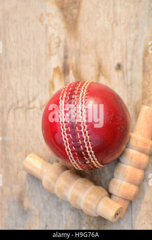 Balle de cricket et passants avec une ombre sur un fond de bois.