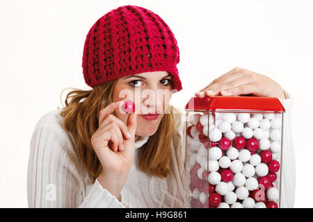 Jeune femme tenant un chewing-gum, à côté d'un gumball machine Banque D'Images