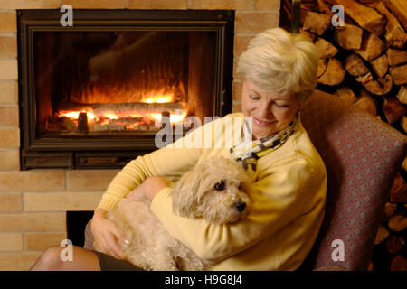 Femme et chien à la cheminée Banque D'Images