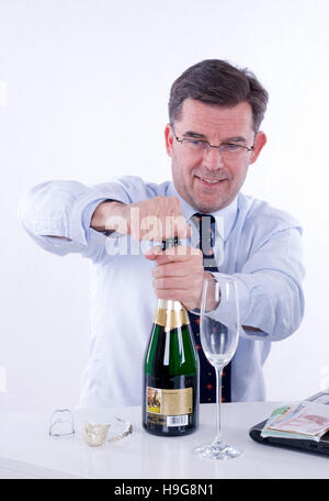 Businessman drinking Sparkling wine dans le bureau Banque D'Images