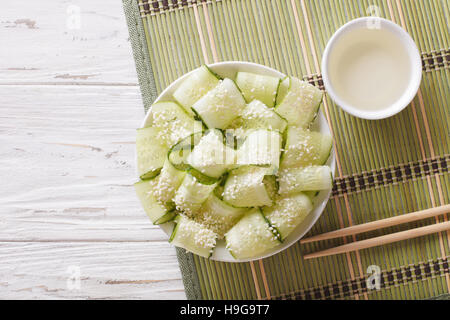 Sunomono japonais avec salade de concombre frais et de graines de sésame dans un bol près du dessus horizontale. Banque D'Images