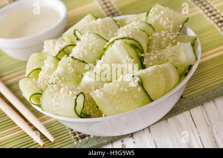 Salade de concombre frais japonais, le gingembre et les graines de sésame close up dans un bol. Banque D'Images