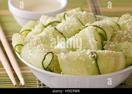 Sunomono japonais avec salade de concombre frais et de graines de sésame close up dans un bol. Banque D'Images