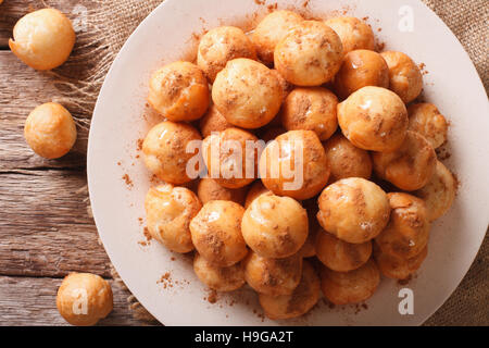 Loukoumades grecque beignets au miel et cannelle gros plan sur une plaque horizontale vue du dessus. Banque D'Images