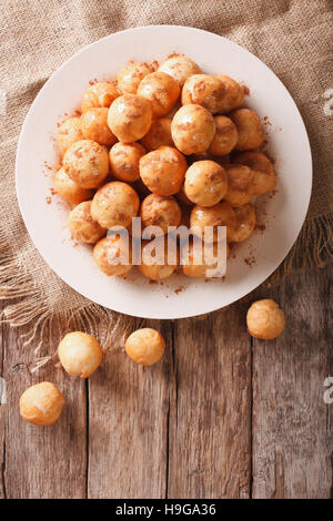 Loukoumades beignets au miel et cannelle gros plan sur une assiette. vertical Vue de dessus Banque D'Images