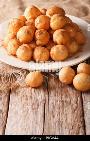 La cuisine méditerranéenne : beignets frits avec du miel et de la cannelle sur la table verticale. Banque D'Images