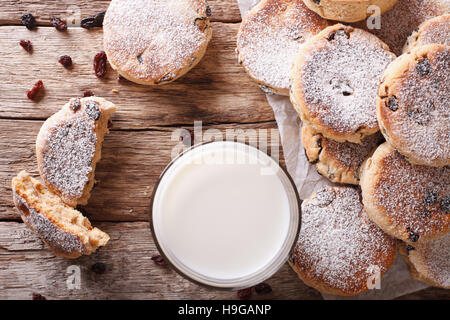 Des gâteaux gallois avec des raisins secs et du lait sur la table horizontale vue du dessus. Banque D'Images