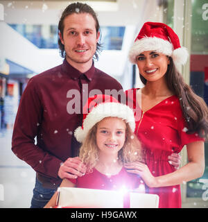 Image composite de portrait de famille en tenue de Noël avec des cadeaux permanent Banque D'Images