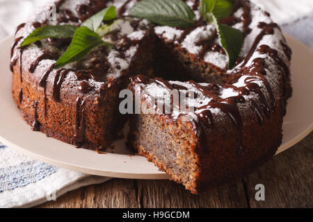 Gâteau aux Graines de pavot avec du sucre en poudre et la menthe close-up sur la table horizontale. Banque D'Images