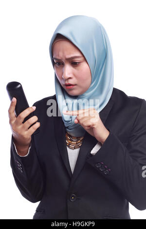 Les femmes d'affaires en colère tout en pointant son doigt sur le téléphone isolé sur fond blanc Banque D'Images