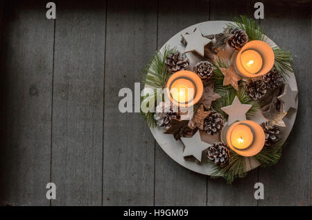 Bougies de Noël avec des pommes de pin, branches de sapins et étoiles sur table en bois. Banque D'Images